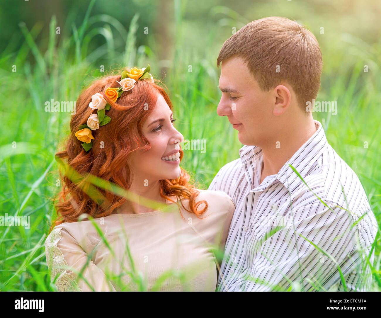 Coppia felice nel parco, Sposa Bella e bello sposo seduto sul fresco verde erba, amore e felicità nel giorno di nozze Foto Stock