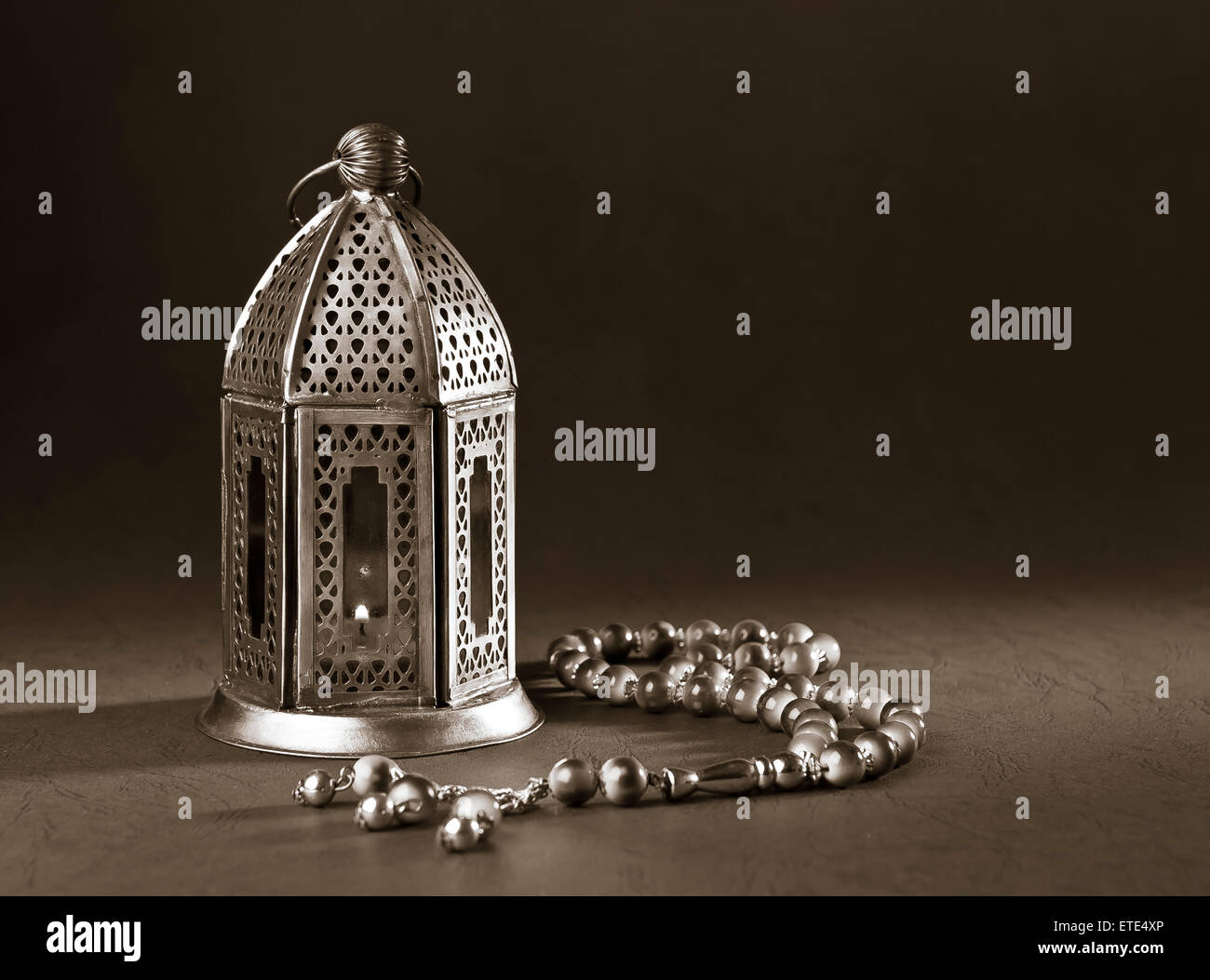 Un metallico lampada Ramadan islamico con i grani del rosario su sfondo nero. Immagine monocromatica. Foto Stock