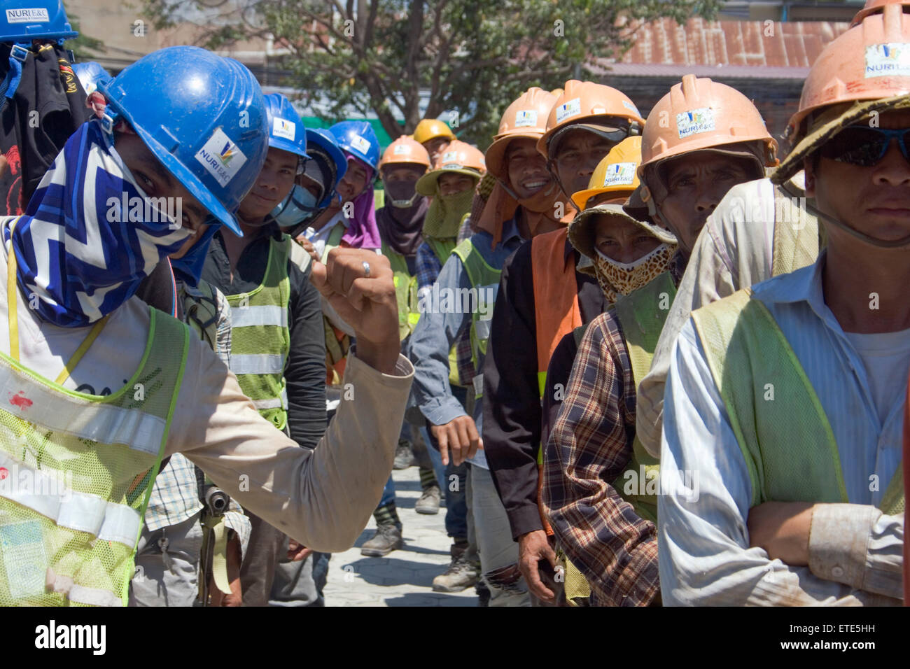 Lavoratori edili prendere parte in esercizi di stretching per migliorare la sicurezza in un cantiere in Phnom Penh Cambogia. Foto Stock