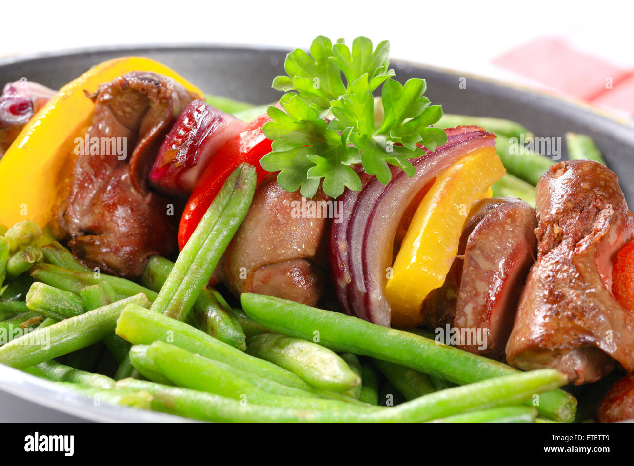 Spiedino di fegato con fagiolini in padella Foto Stock