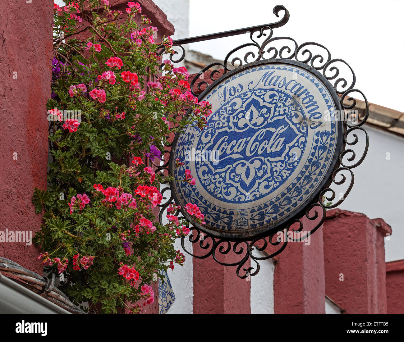 Vintage Coca Cola segno pendente da un edificio accanto a una finestra con vasi di Geranio - Granada, Spagna Foto Stock