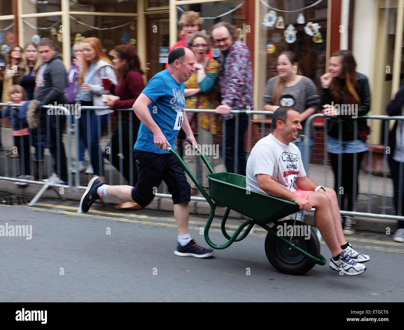 Kington, Herefordshire, Regno Unito. 13th giugno, 2015. Kington Festival Wheelbarrow Race concorrenti in questo anno 39th Wheelbarrow Race ha corso in giro per la città fermandosi a bere in ogni pub lungo il tragitto. Foto Stock