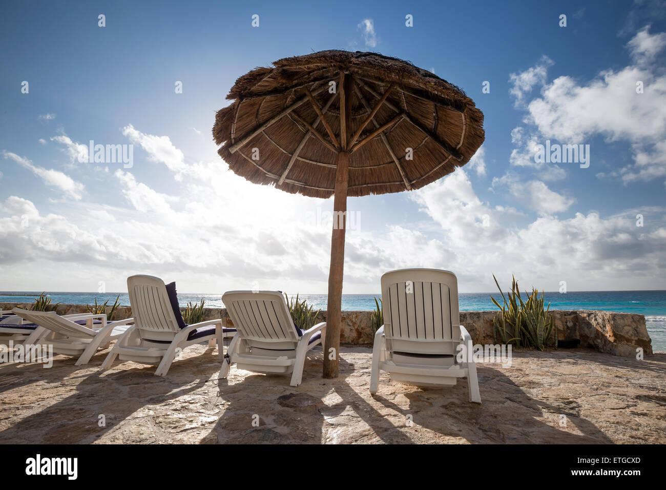 Spiaggia caraibica con erba di ombrelloni e lettini. Concetto di vacanza Foto Stock