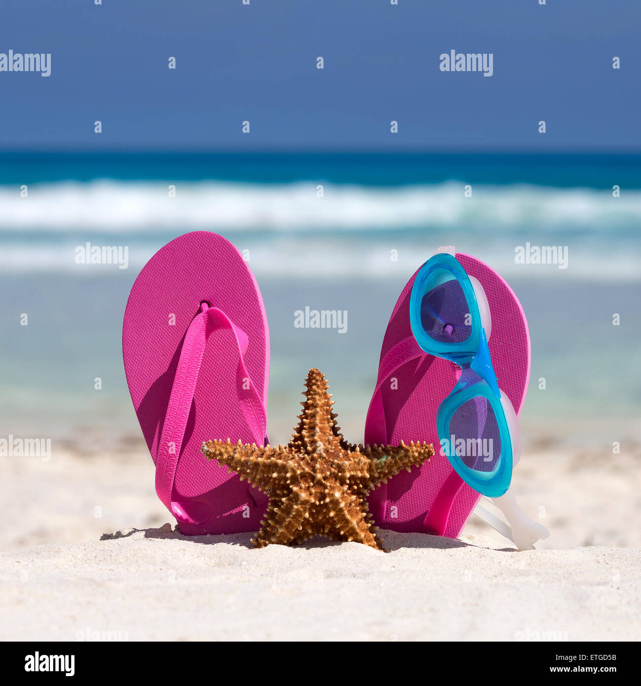 Rosa flip flop, occhiali da nuoto e la stella di mare sulla spiaggia di sabbia bianca. La vacanza estiva concept Foto Stock