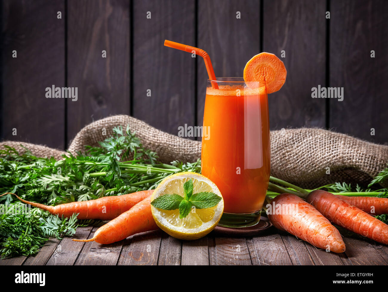 Succo di carota fresco limone e menta su sfondo di legno Foto Stock