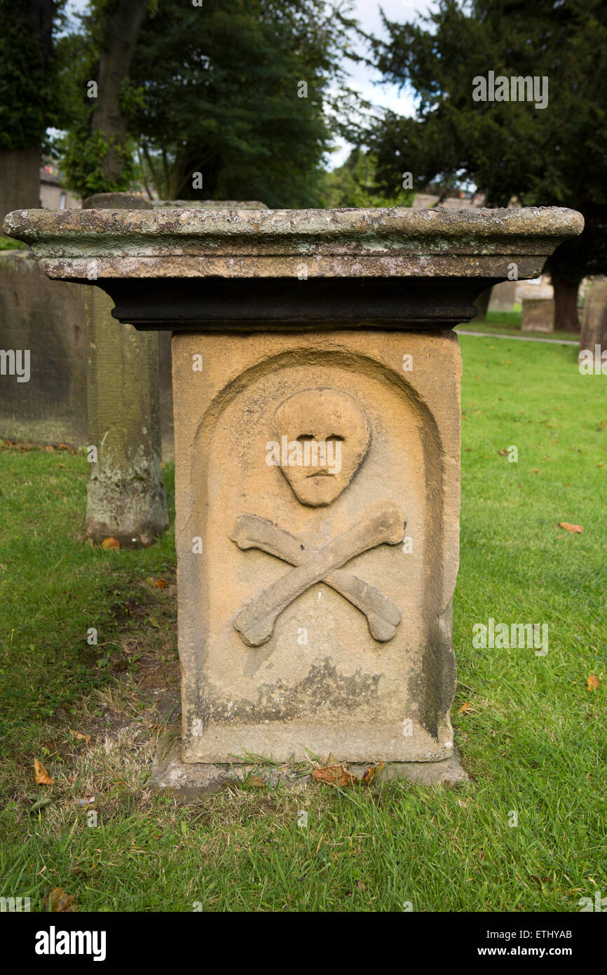 Regno Unito, Inghilterra, Derbyshire, Eyam, St Lawrence il sagrato, grave con il cranio e la morte crossbones motif Foto Stock