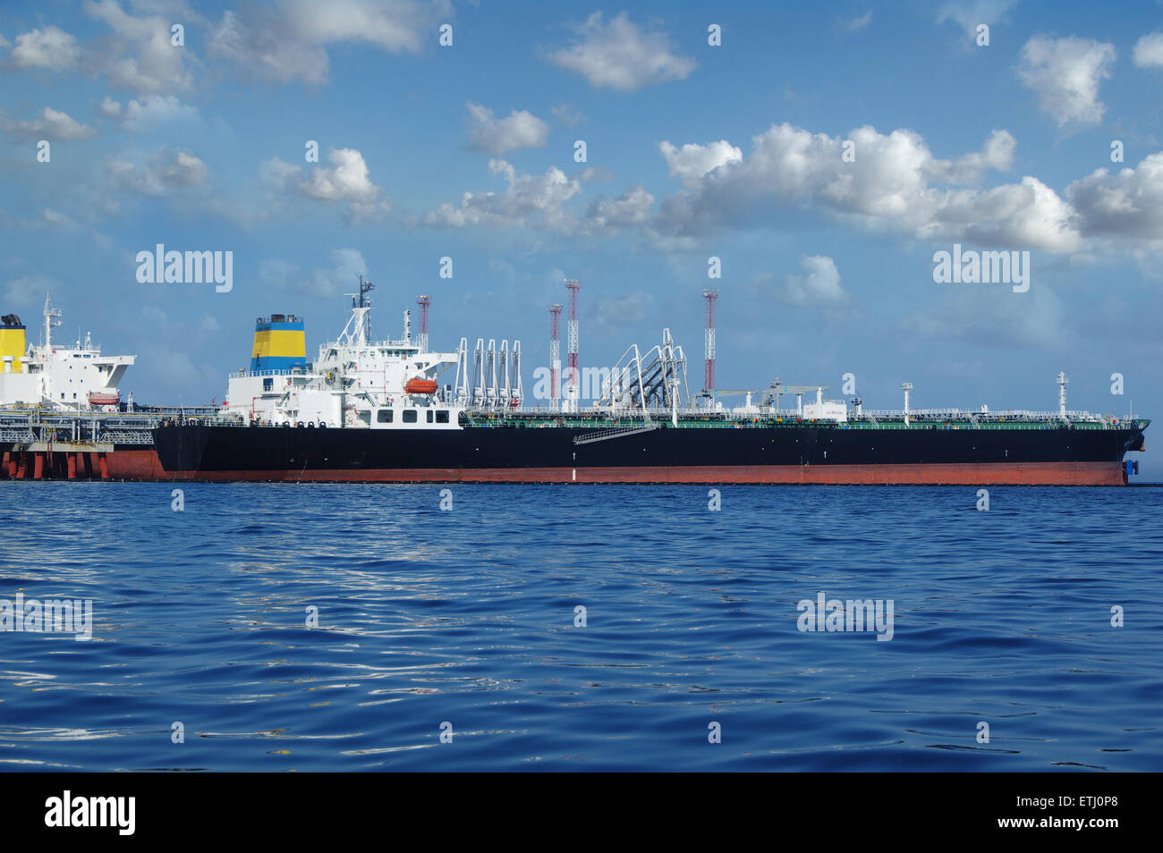 Olio greggio tanker è in fase di caricamento nel porto sullo sfondo di nuvole Foto Stock