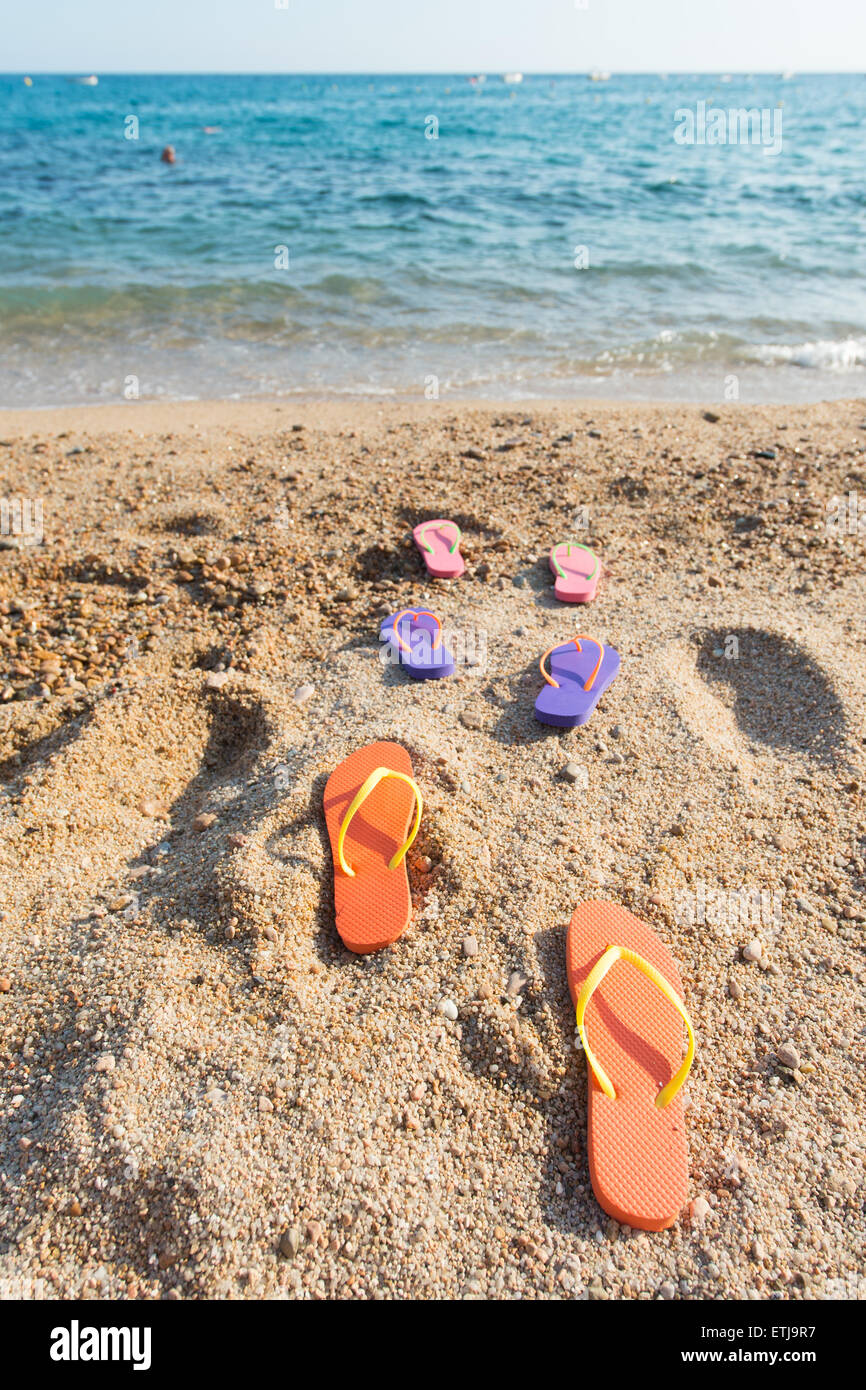 Riga colorata flip flop in spiaggia Foto Stock