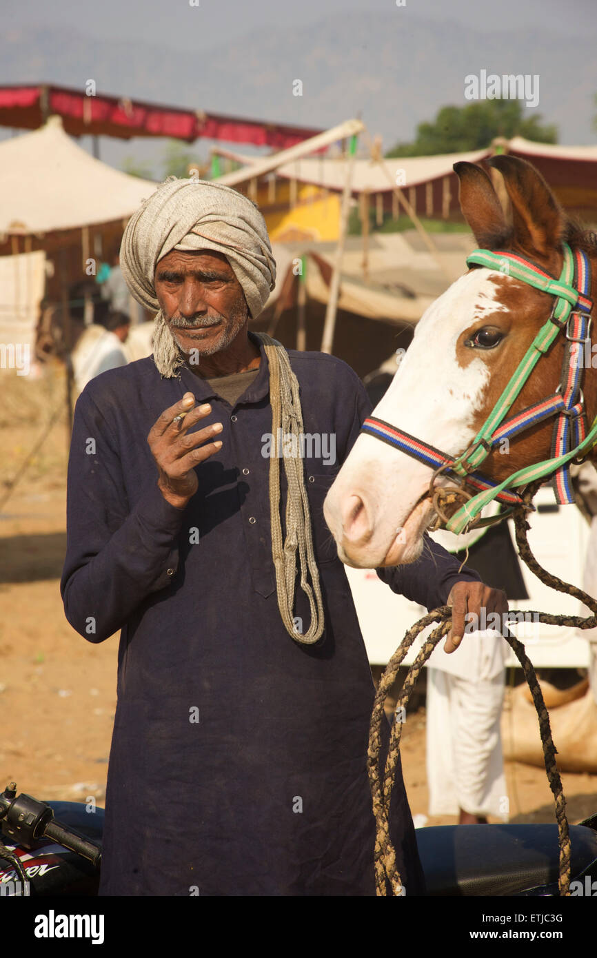 Rajasthani uomo a cavallo presso la fiera di Pushkar. Rajasthan, India Foto Stock