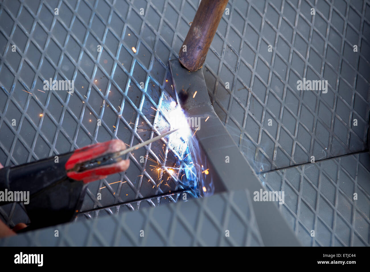 Due uomini al lavoro sulla piattaforma di ferro con saldatura ad arco Foto Stock