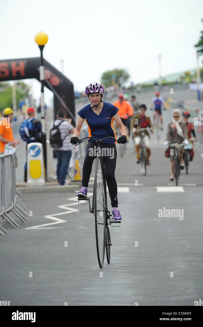 Donna in sella a una Penny Farthing durante una gara ciclistica all'Eastbourne Cycling Festival nell'East Sussex, Inghilterra. Foto Stock