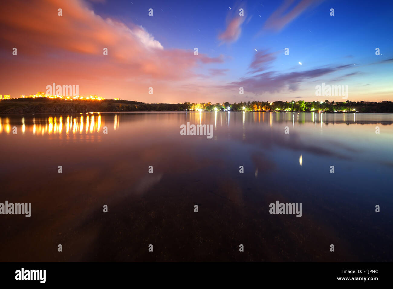 Splendido cielo notturno presso il fiume con le stelle, nuvole e riflessi nell'acqua. Estate in Ucraina Foto Stock