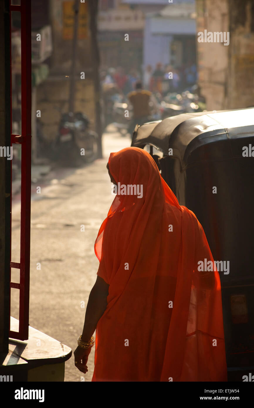 Donna indiana in arancione sari. Scena di strada, Udaipur, Rajasthan, India Foto Stock