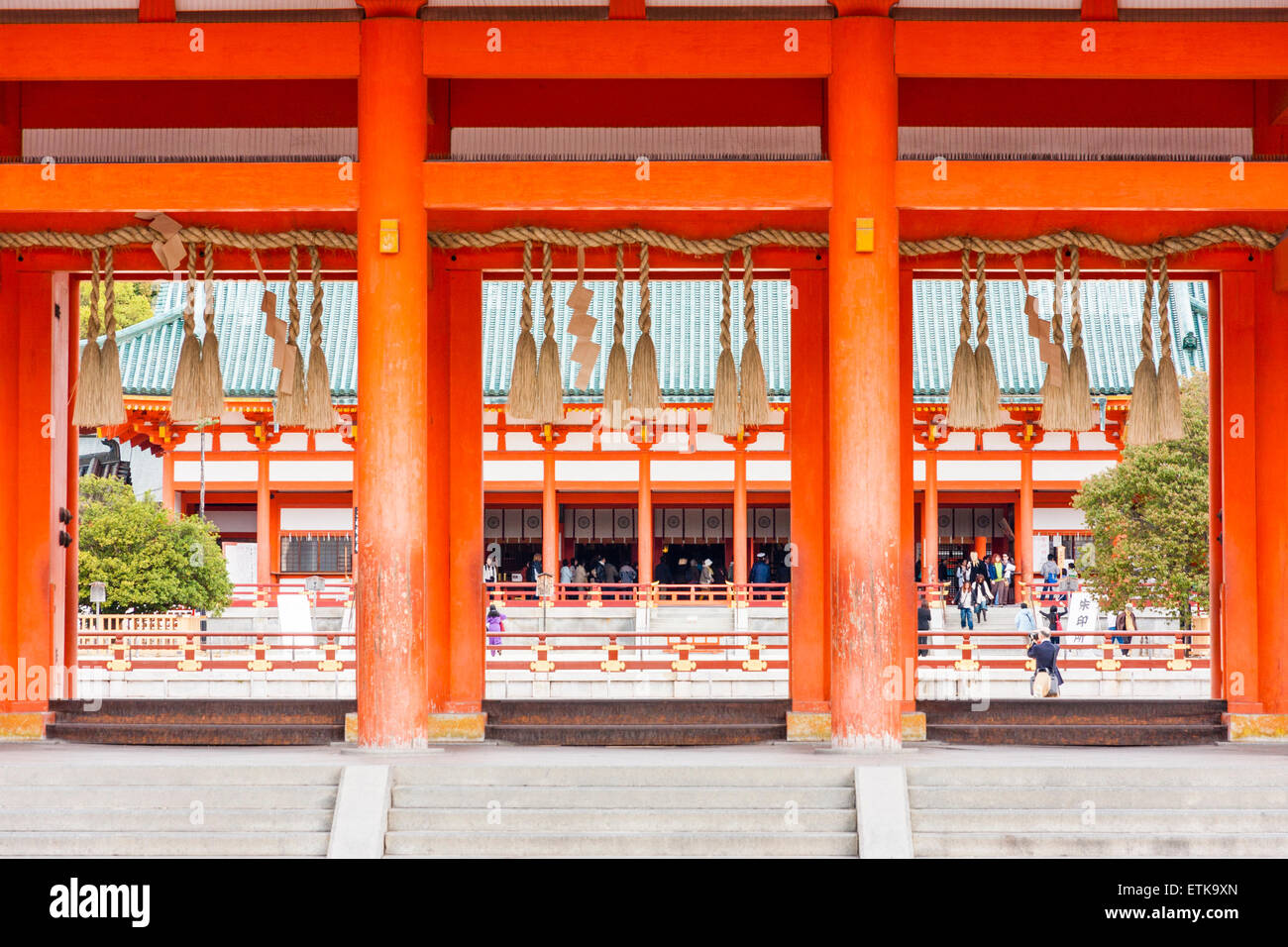 Il vermiglio Daigoku-den, la sala principale del Santuario Heian di Kyoto, visto attraverso le colonne della porta Oten-mon. Corda intrecciata, sospensione shimenawa. Foto Stock