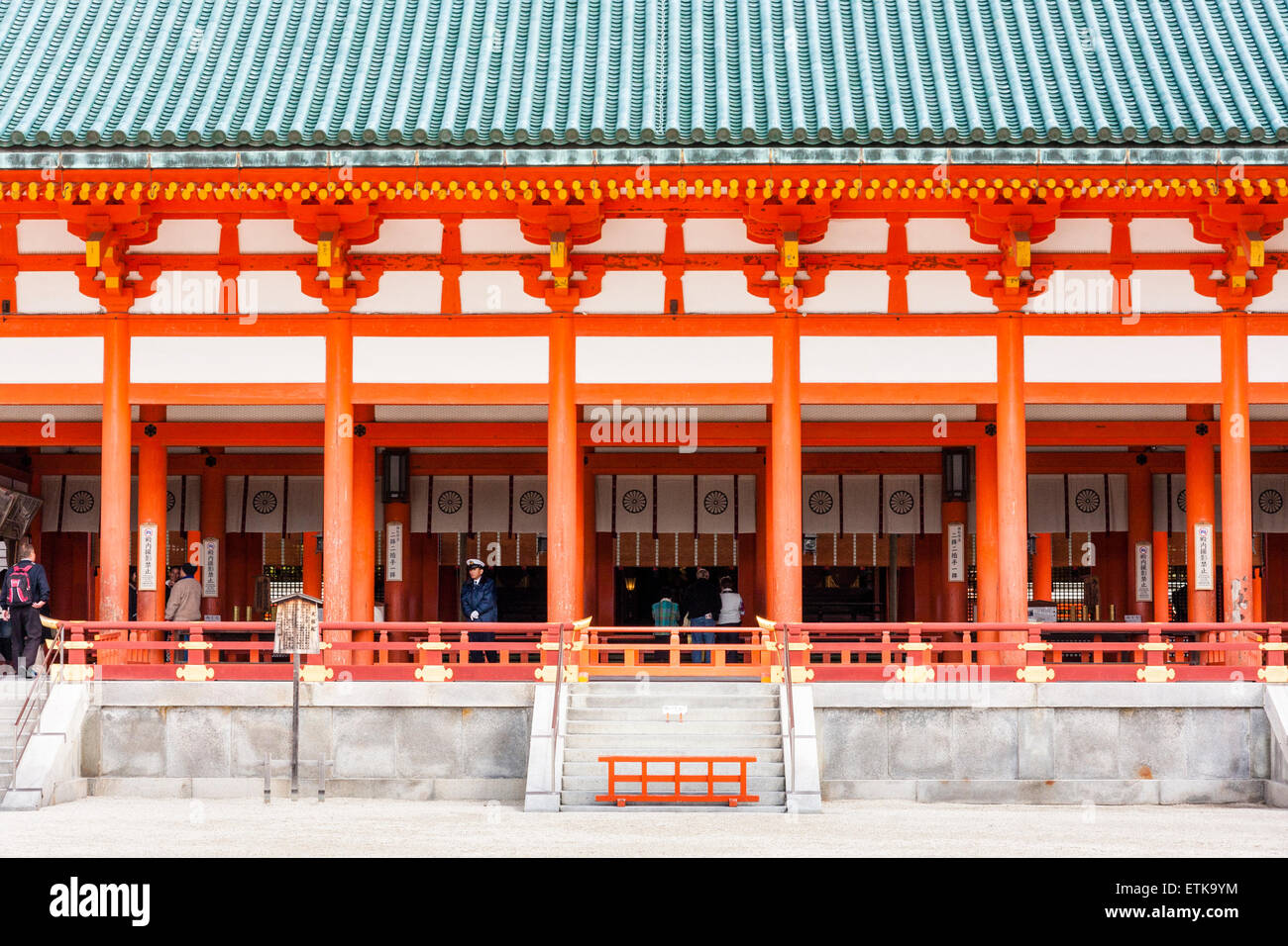 Il santuario Heian a Kyoto, Giappone. Primo piano del vermiglio e bianco Daigoku-den, sala principale con tetto verde. Persone all'interno. Foto Stock