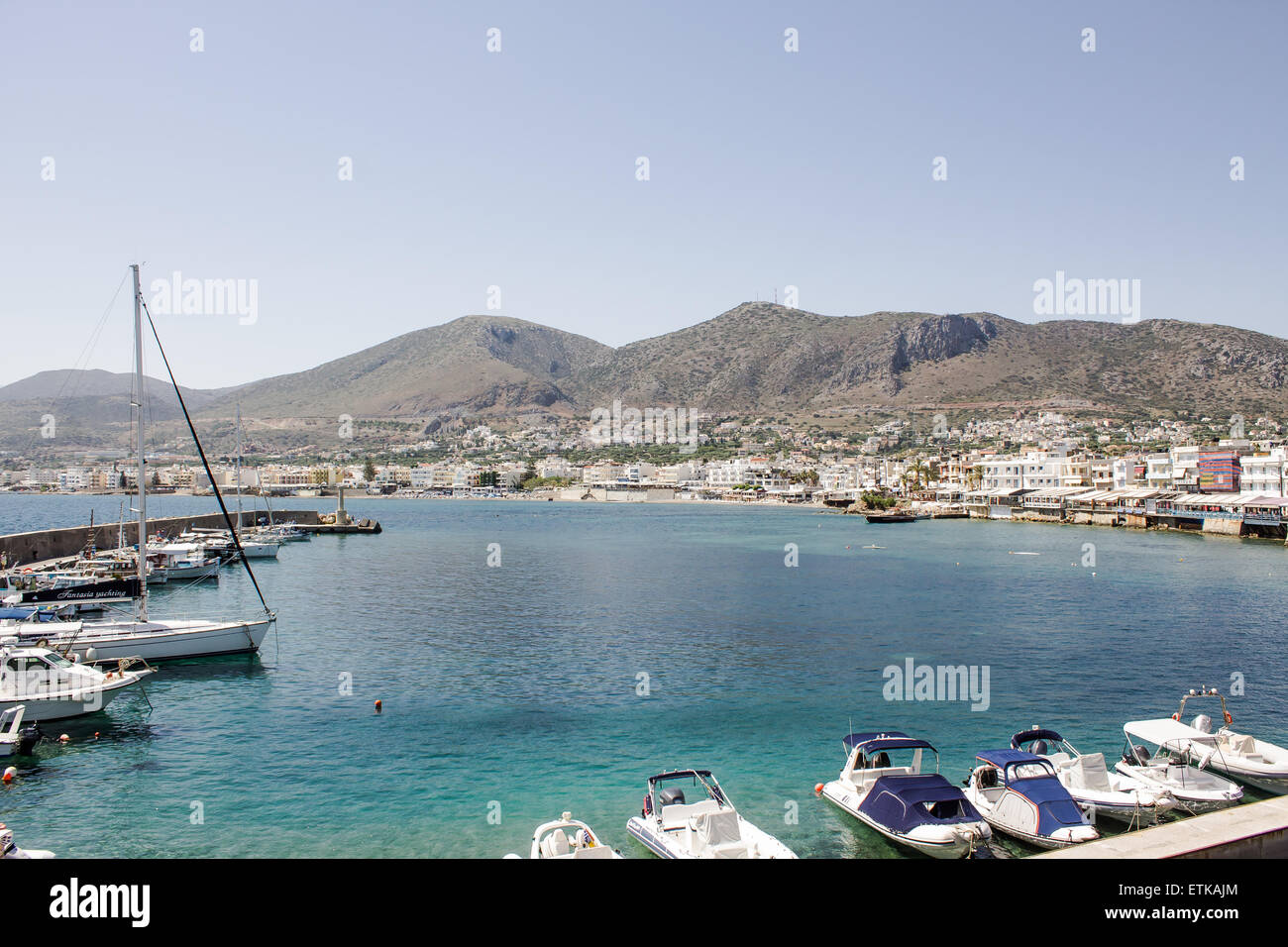 Barche schierate intorno al harbor in una popolare località turistica di Hersonissos Creta. Foto Stock