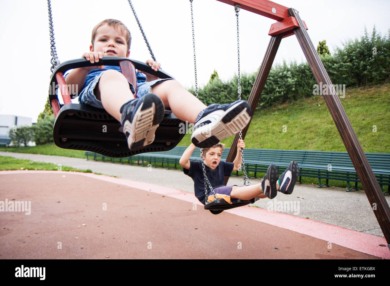 Due bambini che giocano e ridere nello swing Foto Stock