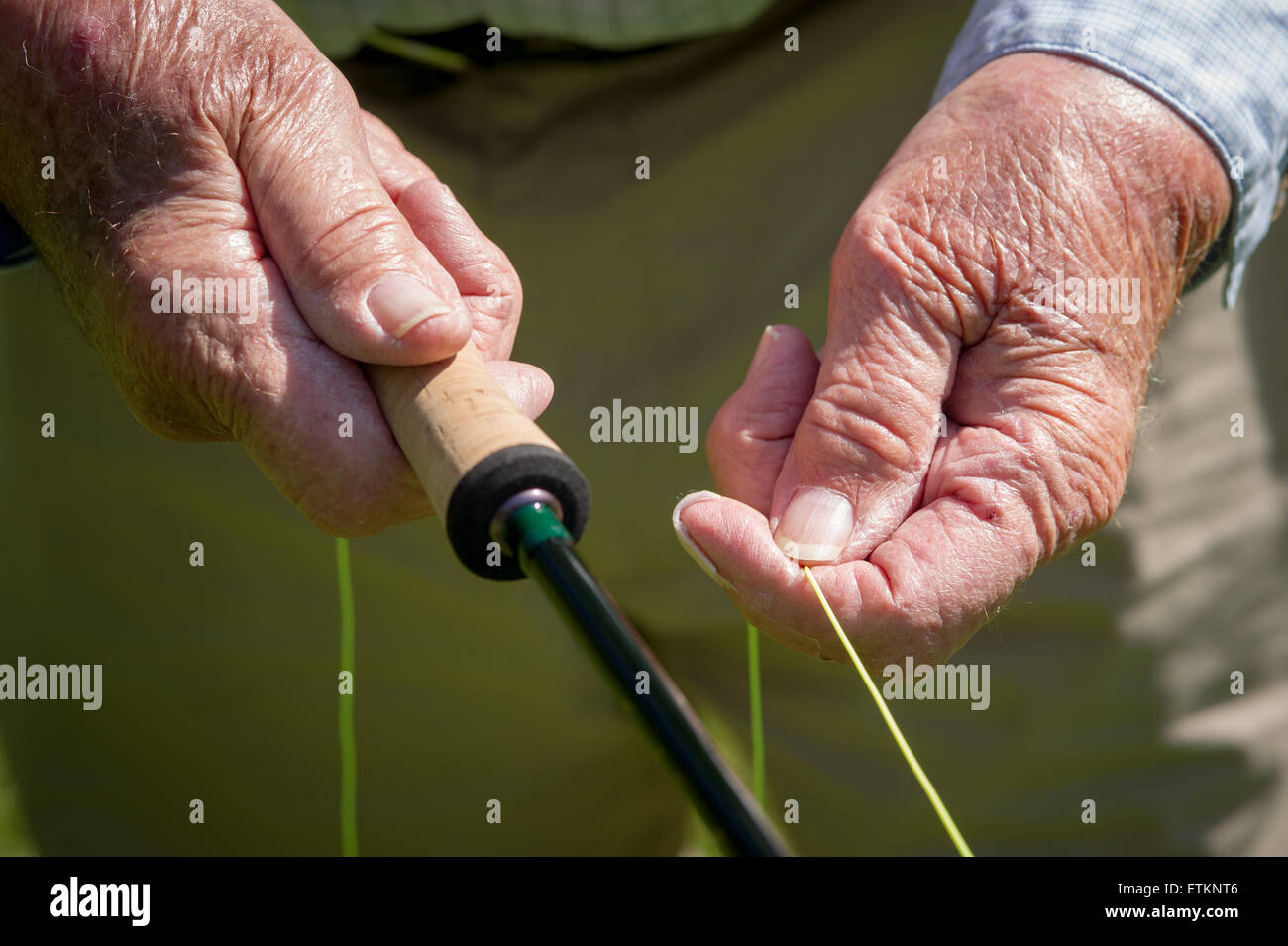 Close-up di Lefty Kreh le mani tenendo la sua cork trattate canna da pesca e la pesca in linea Timonium, Maryland, Stati Uniti d'America Foto Stock