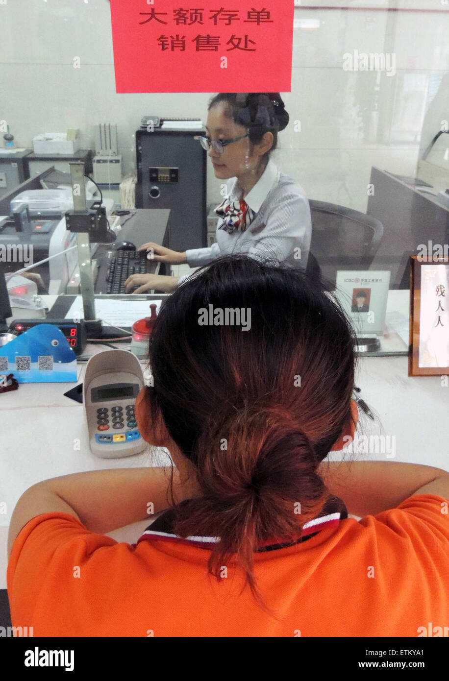 Lianyungang, cinese della provincia di Jiangsu. Il 15 giugno, 2015. Un depositante apre un account dei certificati di deposito (CD) presso una banca di Lianyungang, est cinese della provincia di Jiangsu, 15 giugno 2015. Le nove banche, compresi i "quattro grandi" di proprietà dello stato lenders, iniziato il rilascio del paese del primo lotto di grandi dimensioni di CD su Giugno 15. Gran parte del primo lotto avrà termini di un anno o meno. La soglia di abbonamento per investitori individuali è di 300.000 yuan (circa 49,020 dollari USA) mentre quella per le istituzioni è di 10 milioni di yuan. © Geng Yuhe/Xinhua/Alamy Live News Foto Stock