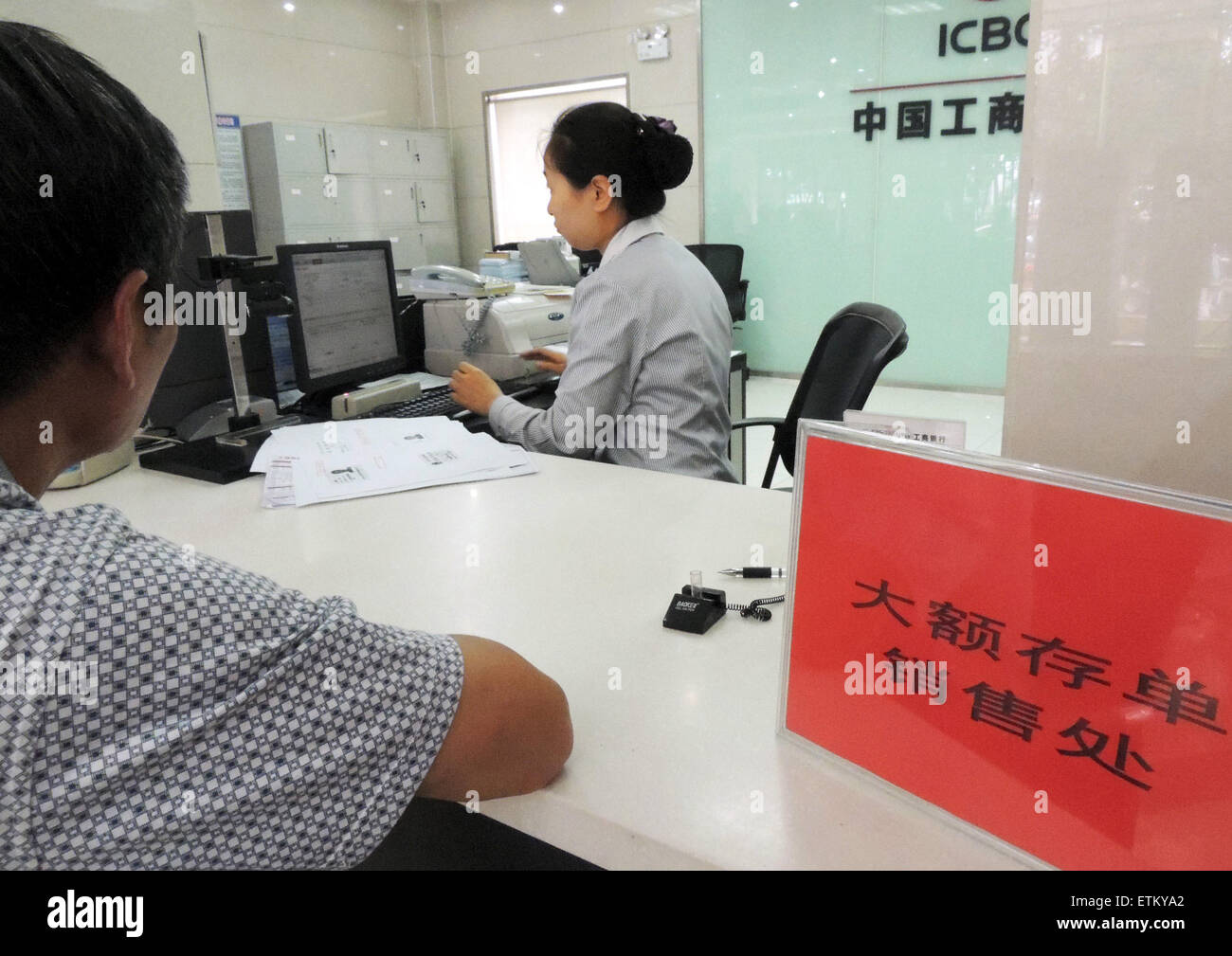 Lianyungang, cinese della provincia di Jiangsu. Il 15 giugno, 2015. Un depositante apre un account dei certificati di deposito (CD) presso una banca di Lianyungang, est cinese della provincia di Jiangsu, 15 giugno 2015. Le nove banche, compresi i "quattro grandi" di proprietà dello stato lenders, iniziato il rilascio del paese del primo lotto di grandi dimensioni di CD su Giugno 15. Gran parte del primo lotto avrà termini di un anno o meno. La soglia di abbonamento per investitori individuali è di 300.000 yuan (circa 49,020 dollari USA) mentre quella per le istituzioni è di 10 milioni di yuan. © Geng Yuhe/Xinhua/Alamy Live News Foto Stock