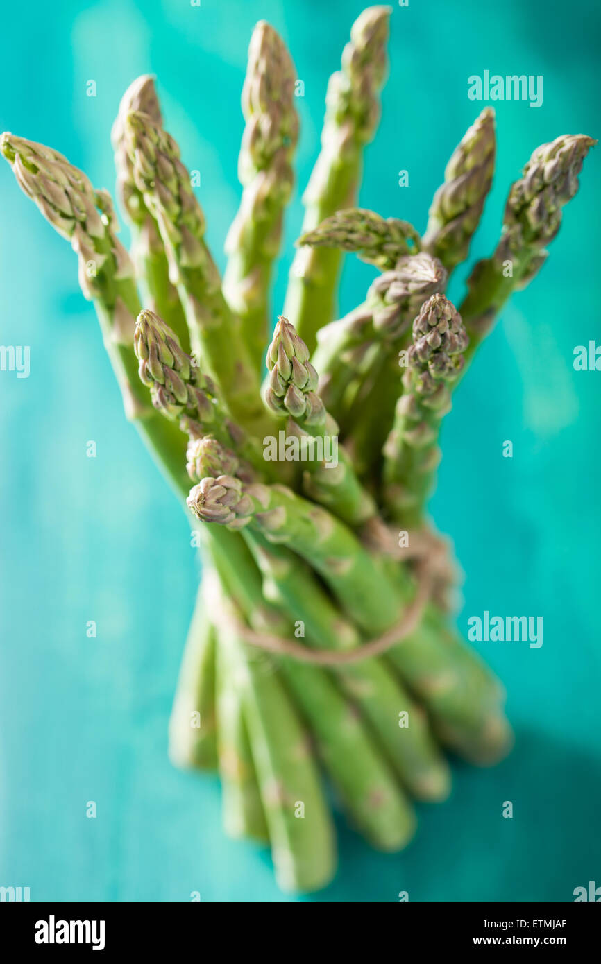 Mazzetto di asparagi freschi su sfondo turchese Foto Stock