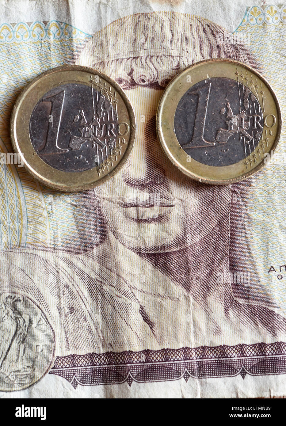 Berlino, Germania. 14 Giugno, 2015. Illustrazione - Due un euro monete coprire gli occhi del dio greco Apollo su un 1000 dracma greca bill a Berlino, Germania, 14 giugno 2015. Foto: Jens Kalaene/dpa/Alamy Live News Foto Stock