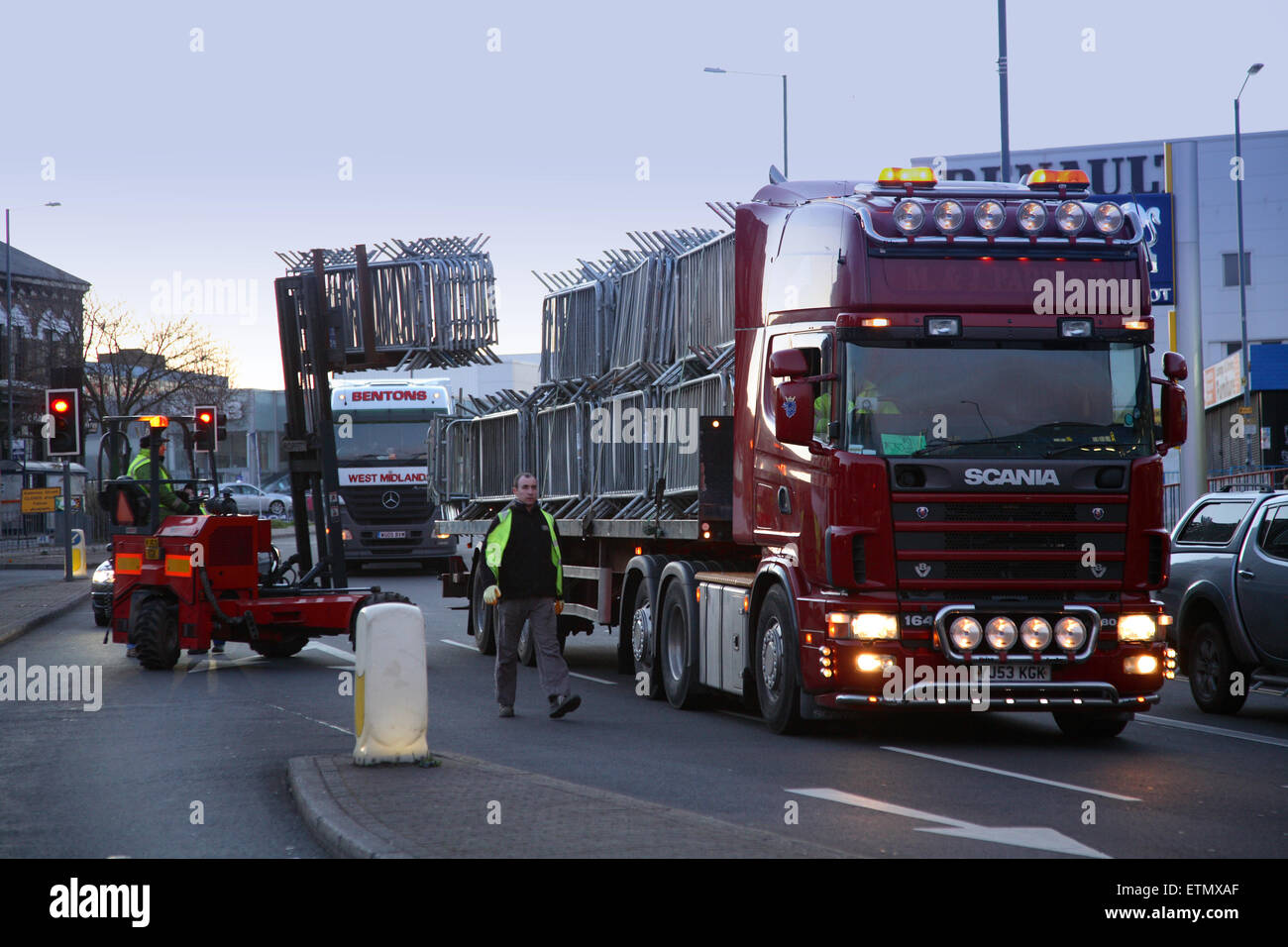 Un carrello elevatore a forca rimuove le barriere pedonale da un camion all'alba come operai preparare per il giorno di San Patrizio parata in Birmingham Foto Stock