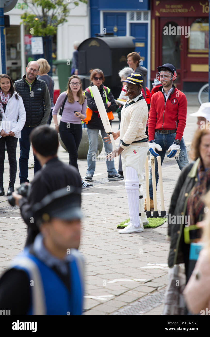 Gruppo di teatro di strada di eseguire un pezzo di cricket in Warwick town center Primavera 2015 Foto Stock