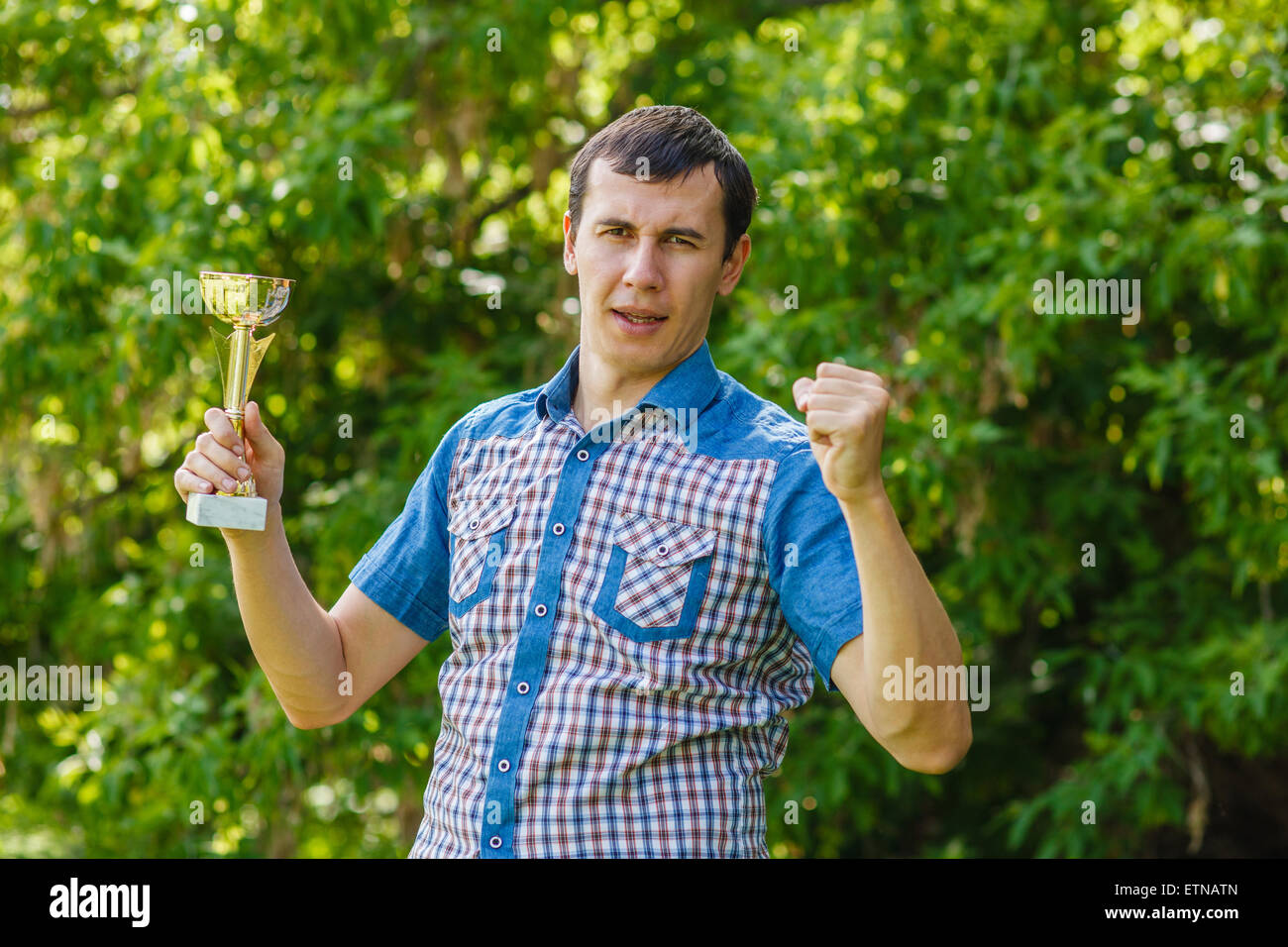 L'uomo tenendo un sports cup su strada la vittoria contro il gree Foto Stock