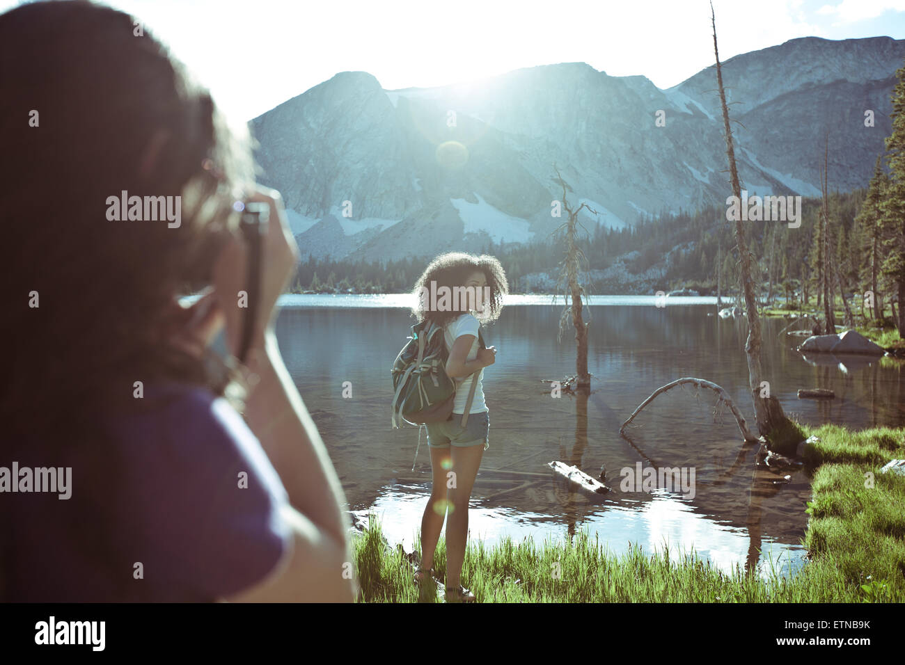 Donna di scattare una foto di un'altra donna in piedi da un lago, Wyoming USA Foto Stock