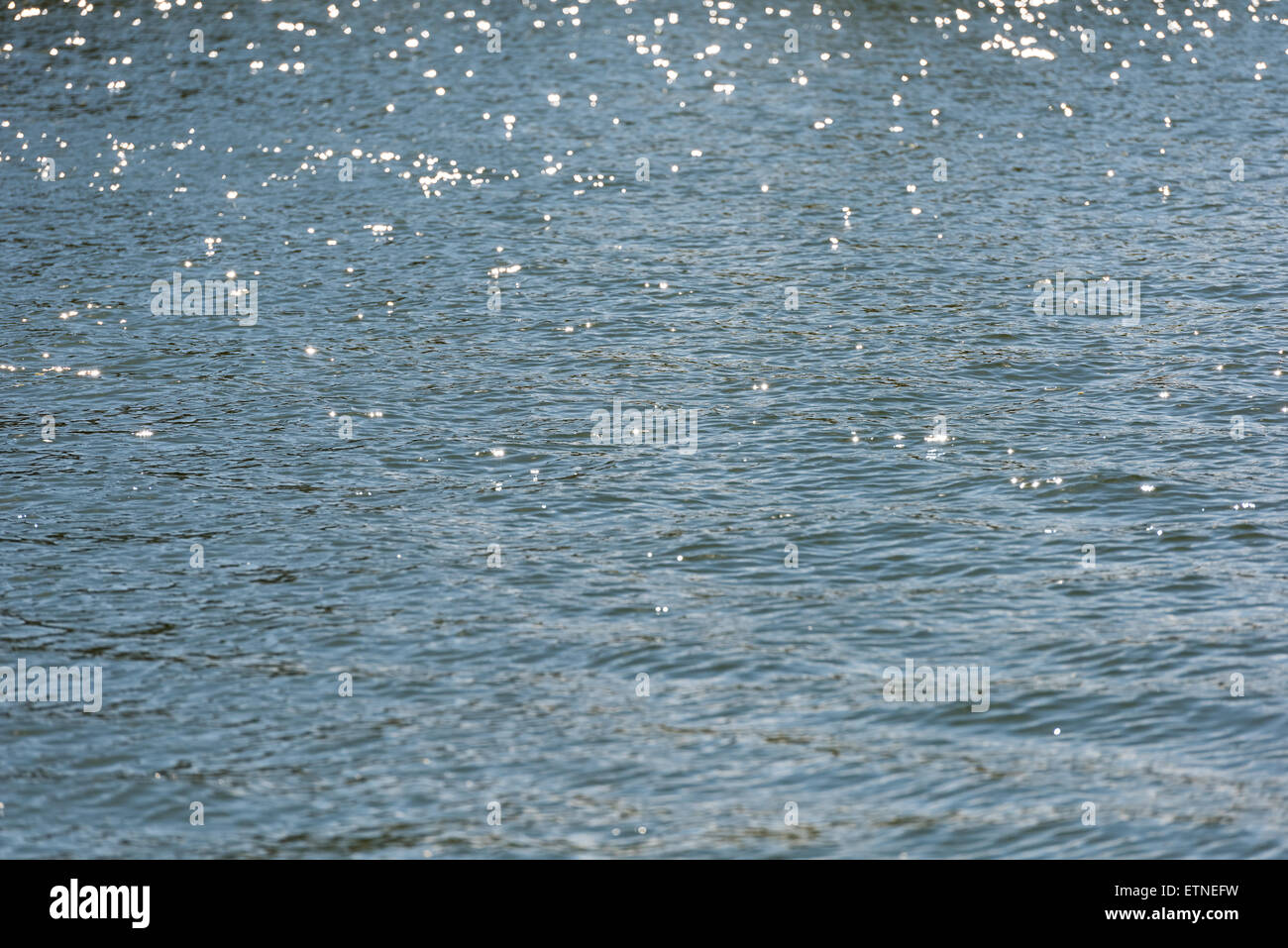 Mare calmo della superficie dell'acqua nella mattina che riflette la luce solare Foto Stock