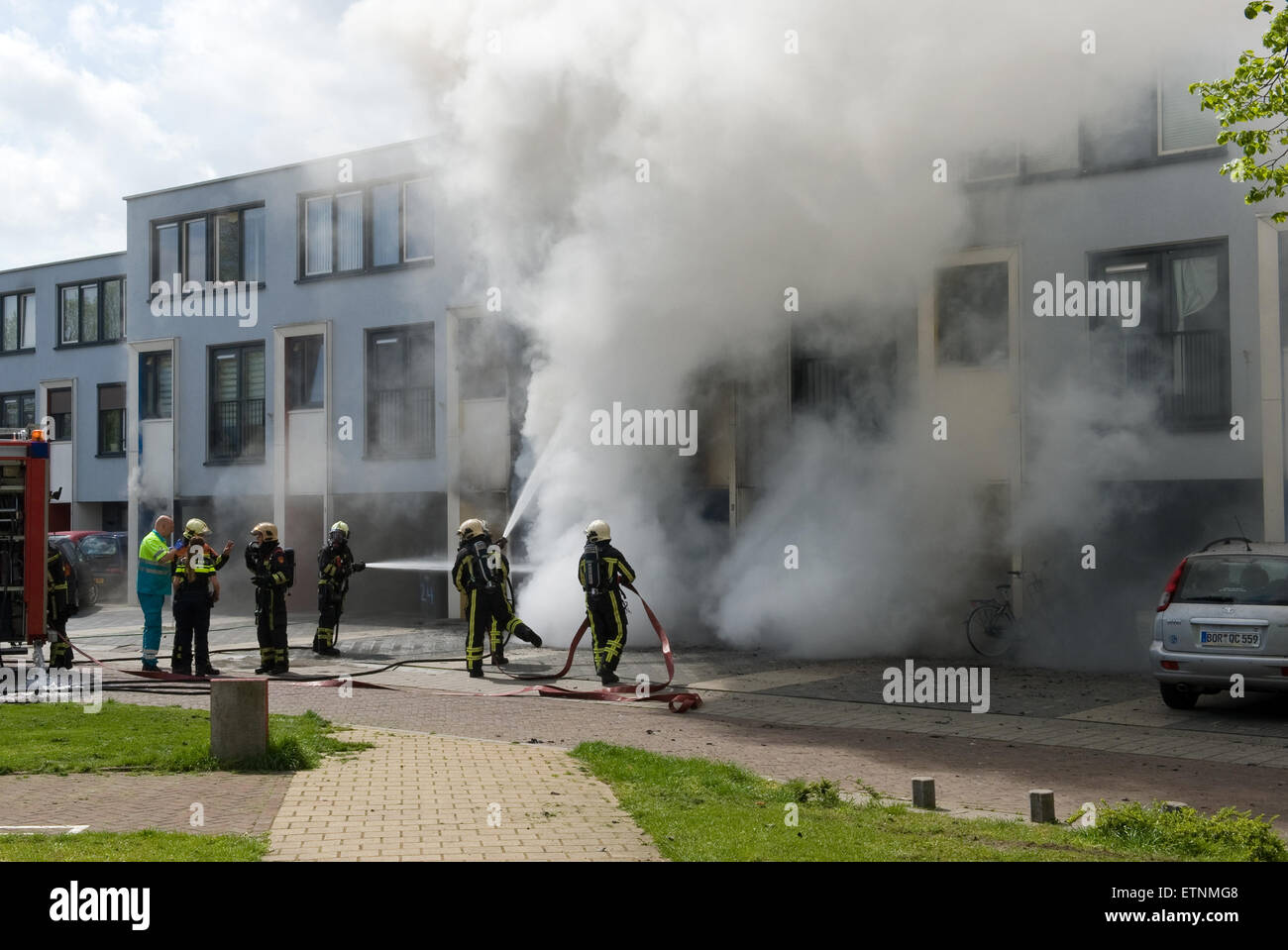 ENSCHEDE, Paesi Bassi - 07 Maggio 2015: i vigili del fuoco sono impegnati a spegnere un incendio in una casa Foto Stock