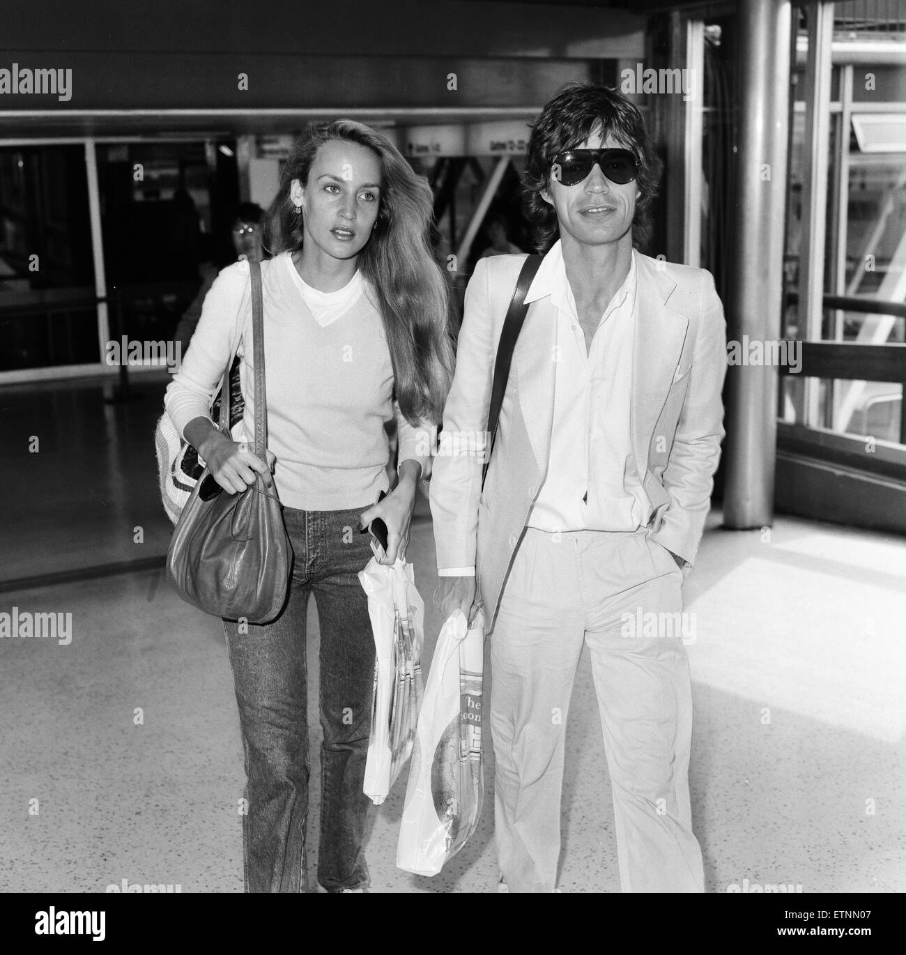 Mick Jagger e fidanzata, modello Jerry Hall, raffigurato all'Aeroporto di Londra Heathrow, uscire per l'India, 28 luglio 1981. Foto Stock