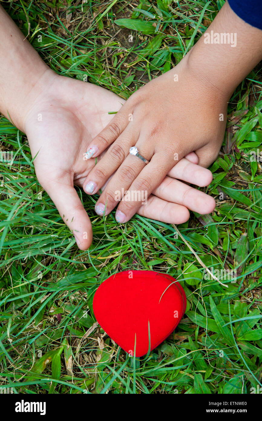 L uomo e la ragazza con la mano con amore il simbolo di forma Foto Stock