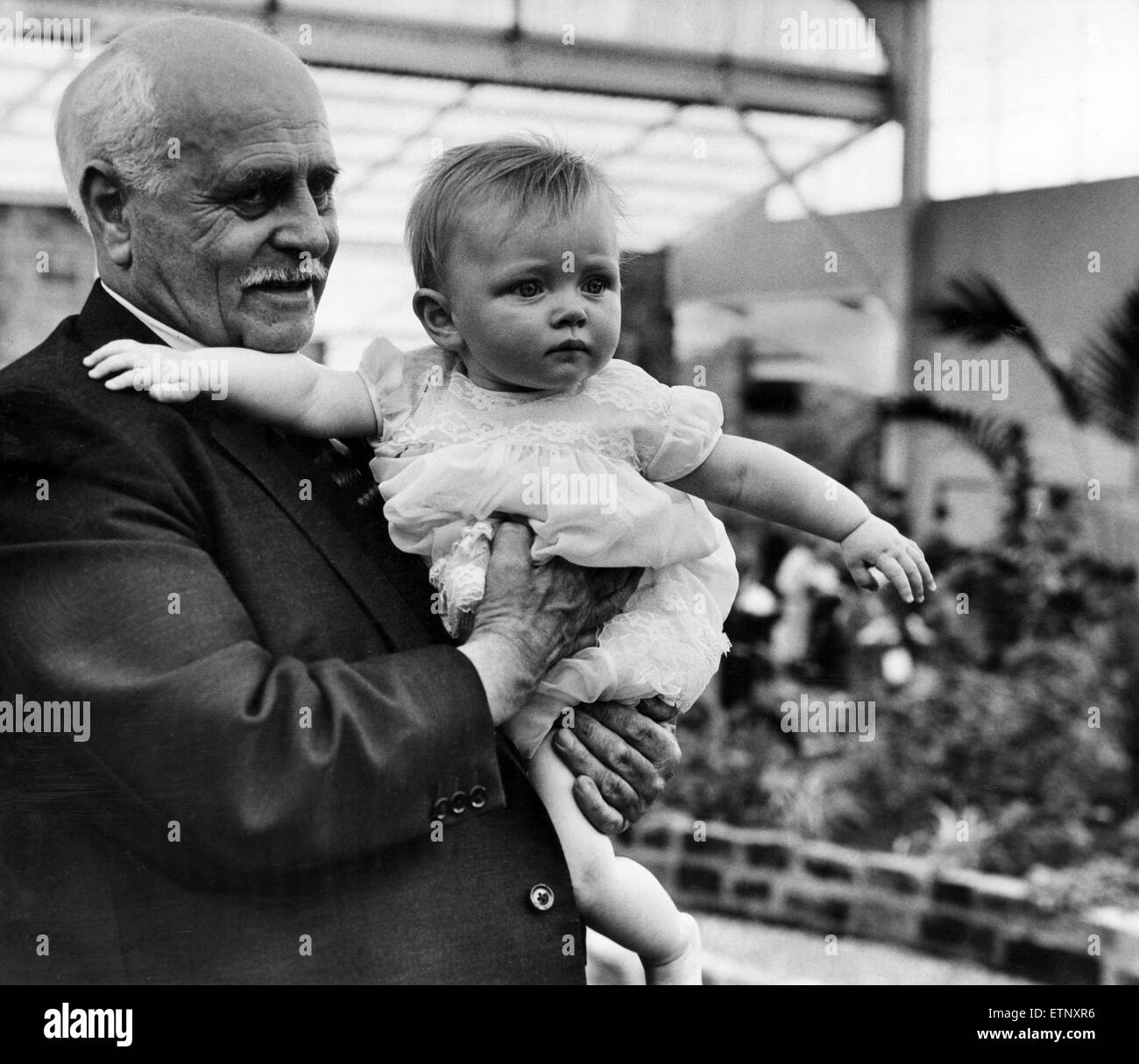George Mottershead, orgogliosi di nonno e direttore di Chester Zoo, nella foto con il suo bambino di 9 mesi, nipote Elizabeth Williams, presso la nuova casa tropicale che ha recentemente aperto, 15 giugno 1964. Foto Stock