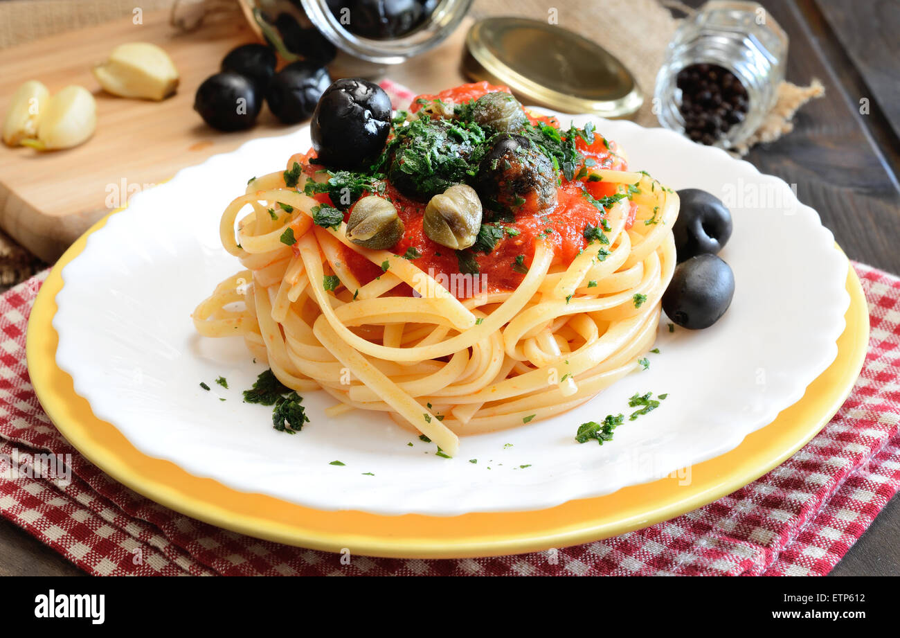 Linguine con salsa di pomodoro e olive nere e capperi Foto Stock
