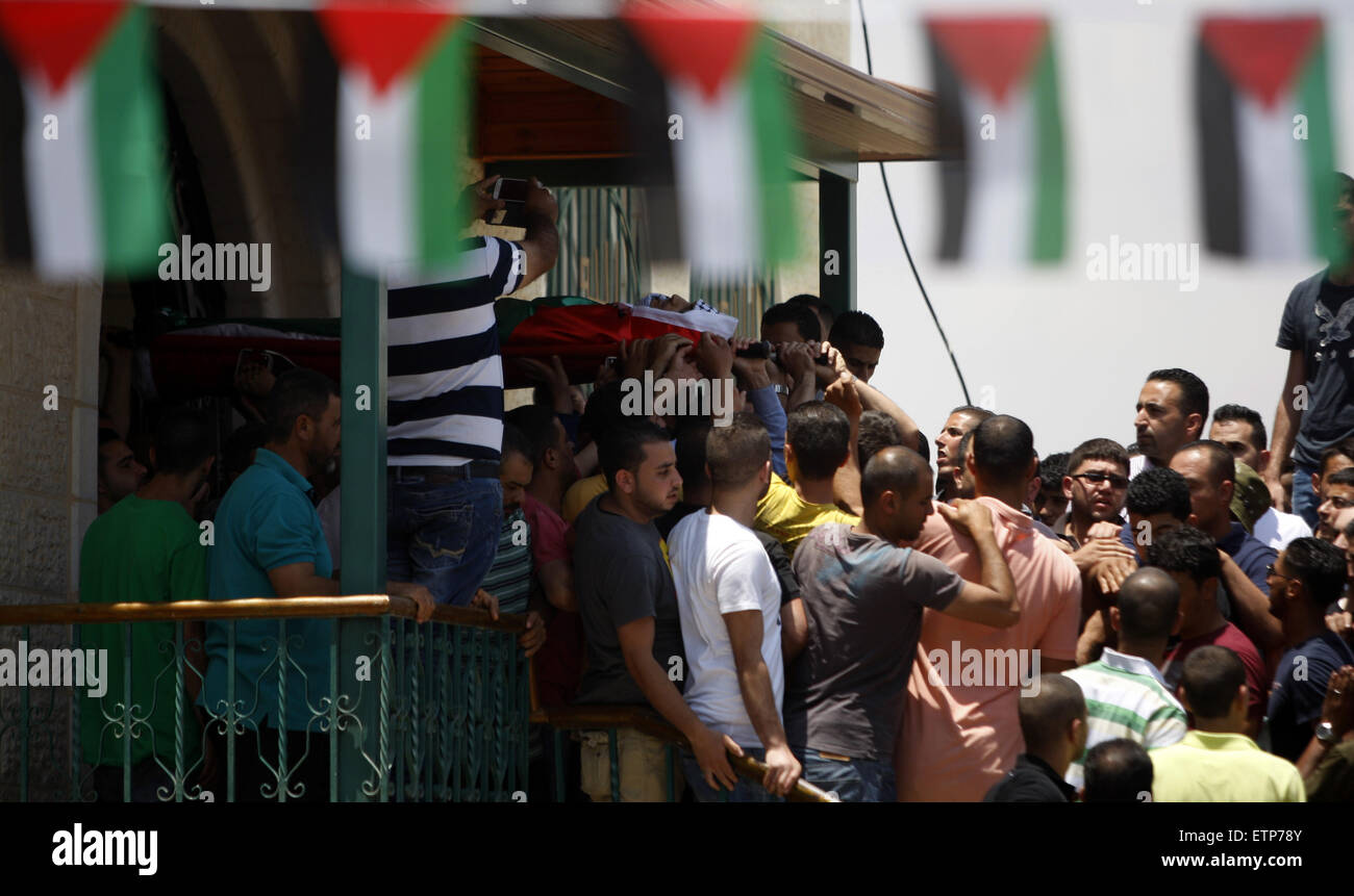 Kafr Malik, West Bank, Territorio palestinese. 14 Giugno, 2015. Persone in lutto portano il corpo di 21-anno-vecchio Abdallah palestinese Ghanayem, durante il suo funerale nel villaggio di Kafr Malik, a nord-est di Ramallah il 14 giugno 2015. Un portavoce militare ha detto che i palestinesi avevano è morto dopo aver gettato un dispositivo incendiario a una jeep e il veicolo capovolto su di lui. Sicurezza palestinese fonti, soldati israeliani uccisi Ghanayem colpendo lui con la jeep durante gli scontri vicino a Ramallah in Cisgiordania occupata © Shadi Hatem APA/images/ZUMA filo/Alamy Live News Foto Stock