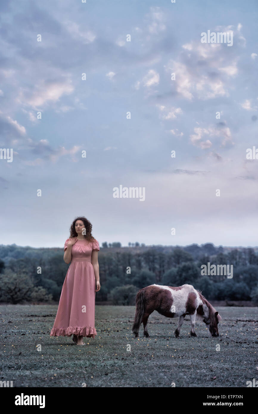 Una donna con un pony su un paddock Foto Stock