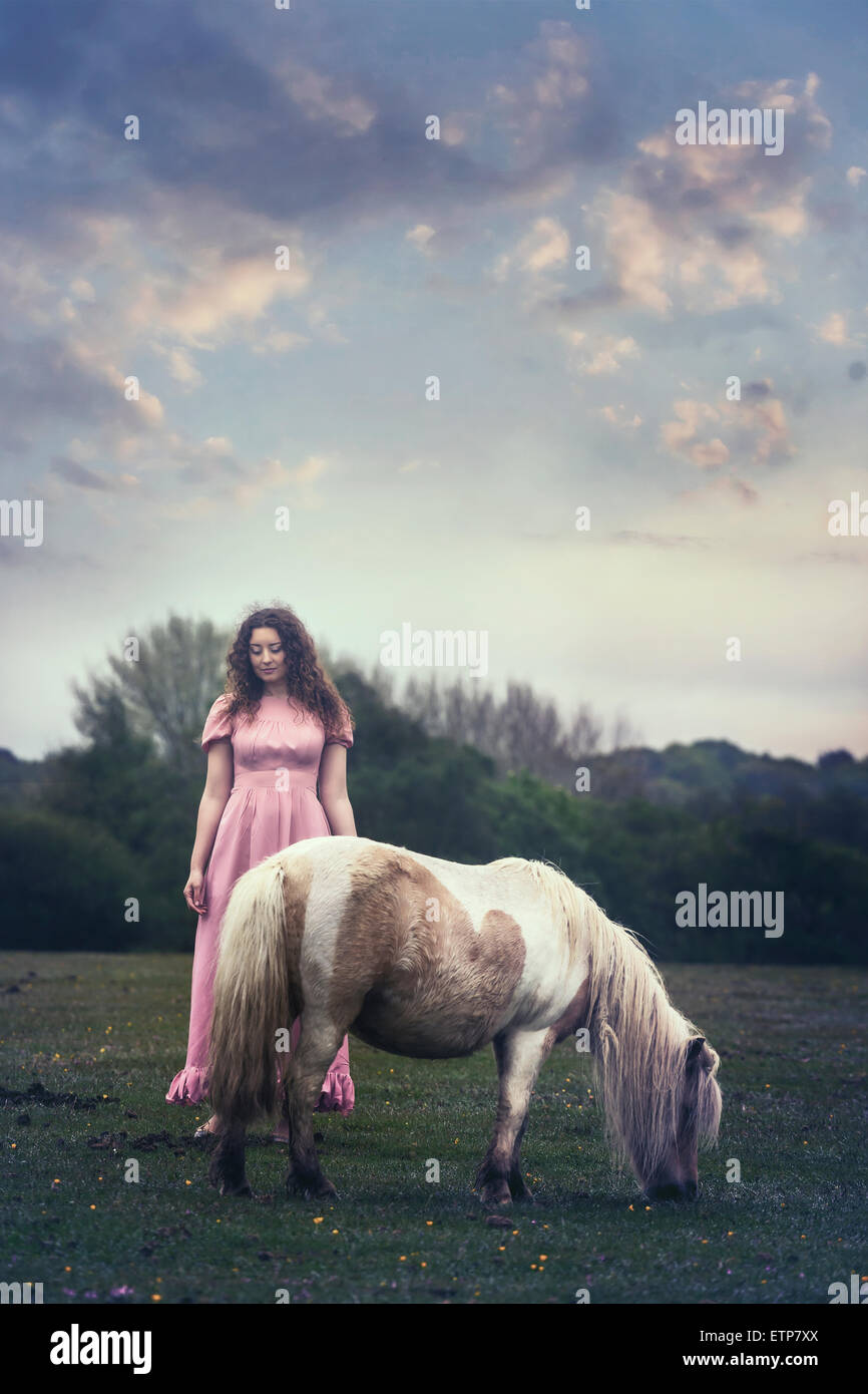 Una donna con un pony su un paddock Foto Stock