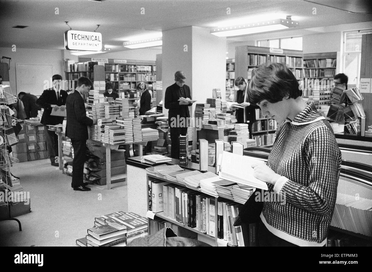 Signora giovane la lettura di un libro di testo nel libro tecnico dipartimento a Foyles bookshop in carbonizzazione Cross Road, Londra. Circa il luglio 1966 Foto Stock