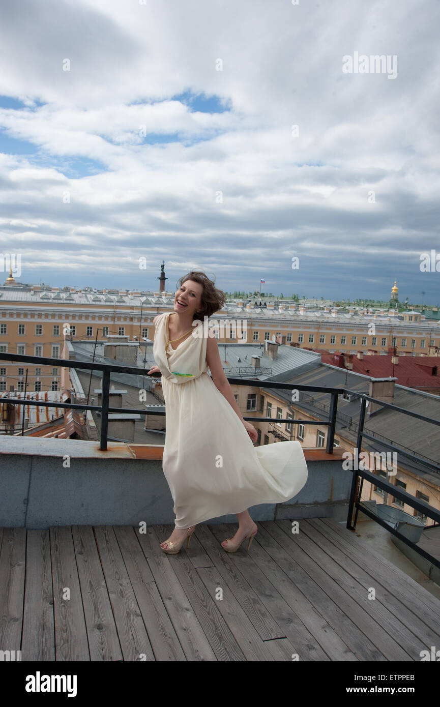 Splendida donna sorridente nel vento sul tetto Foto Stock