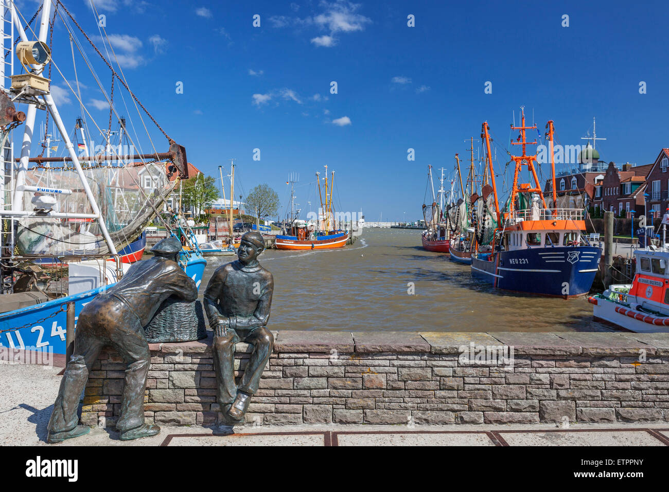 Monumento di pesca "vecchi e giovani pescatori' e gamberetti imbarcazione s al porto di Neuharlingersiel, Frisia orientale, Bassa Sassonia, Foto Stock