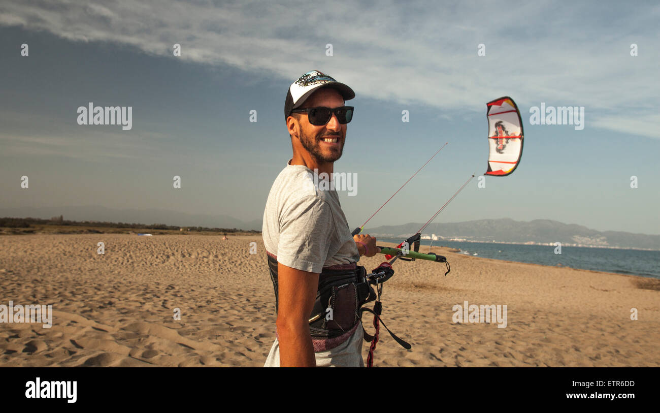 Lonely Kite surf sulla spiaggia di sabbia di holding Kite linee Drago al tramonto, in Costa Brava Girona Spagna, Europa Foto Stock
