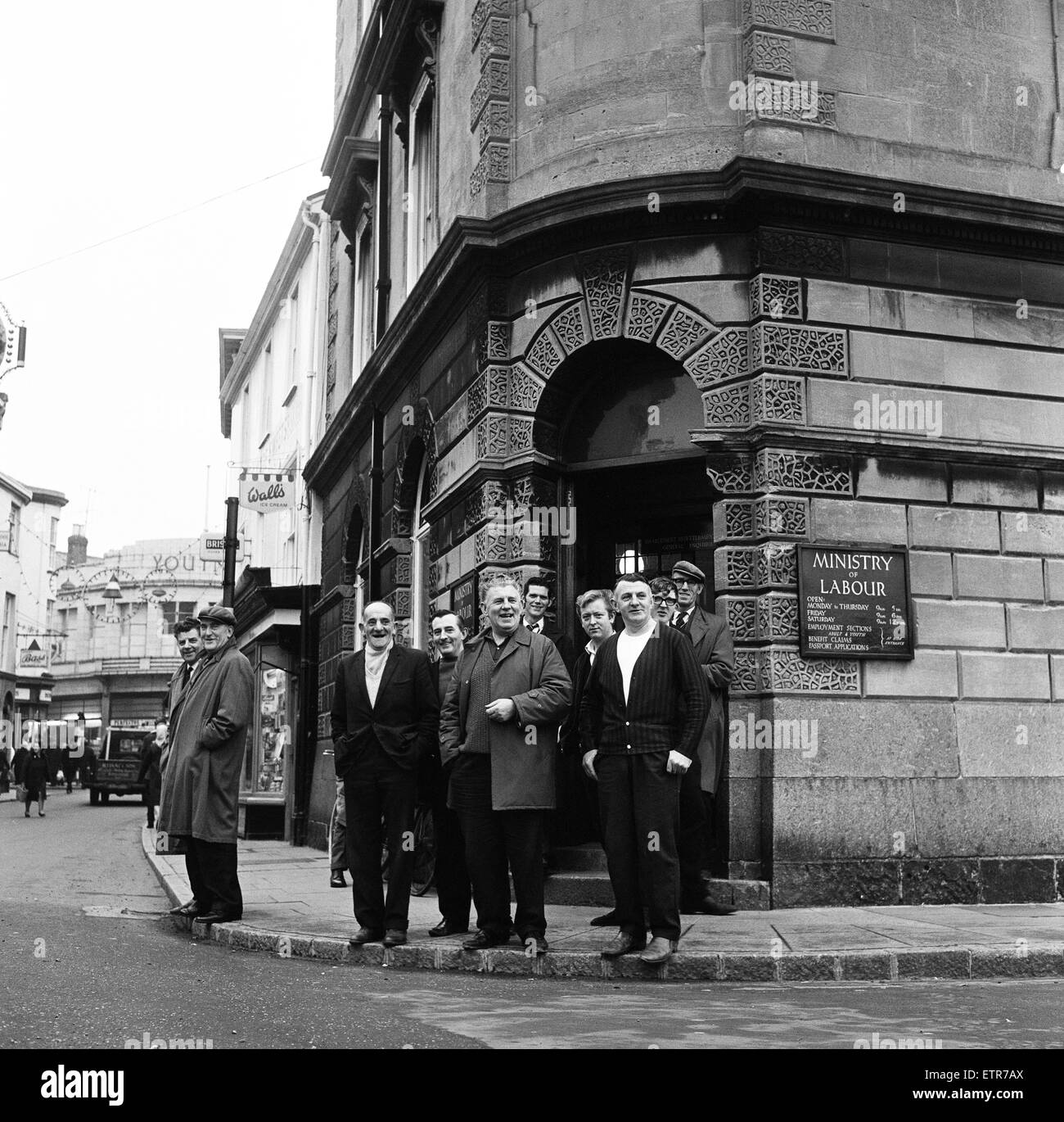 Un gruppo di uomini in piedi al di fuori del Ministero del Lavoro sulla High Street, Barnstaple, North Devon. 9 gennaio 1966. Foto Stock