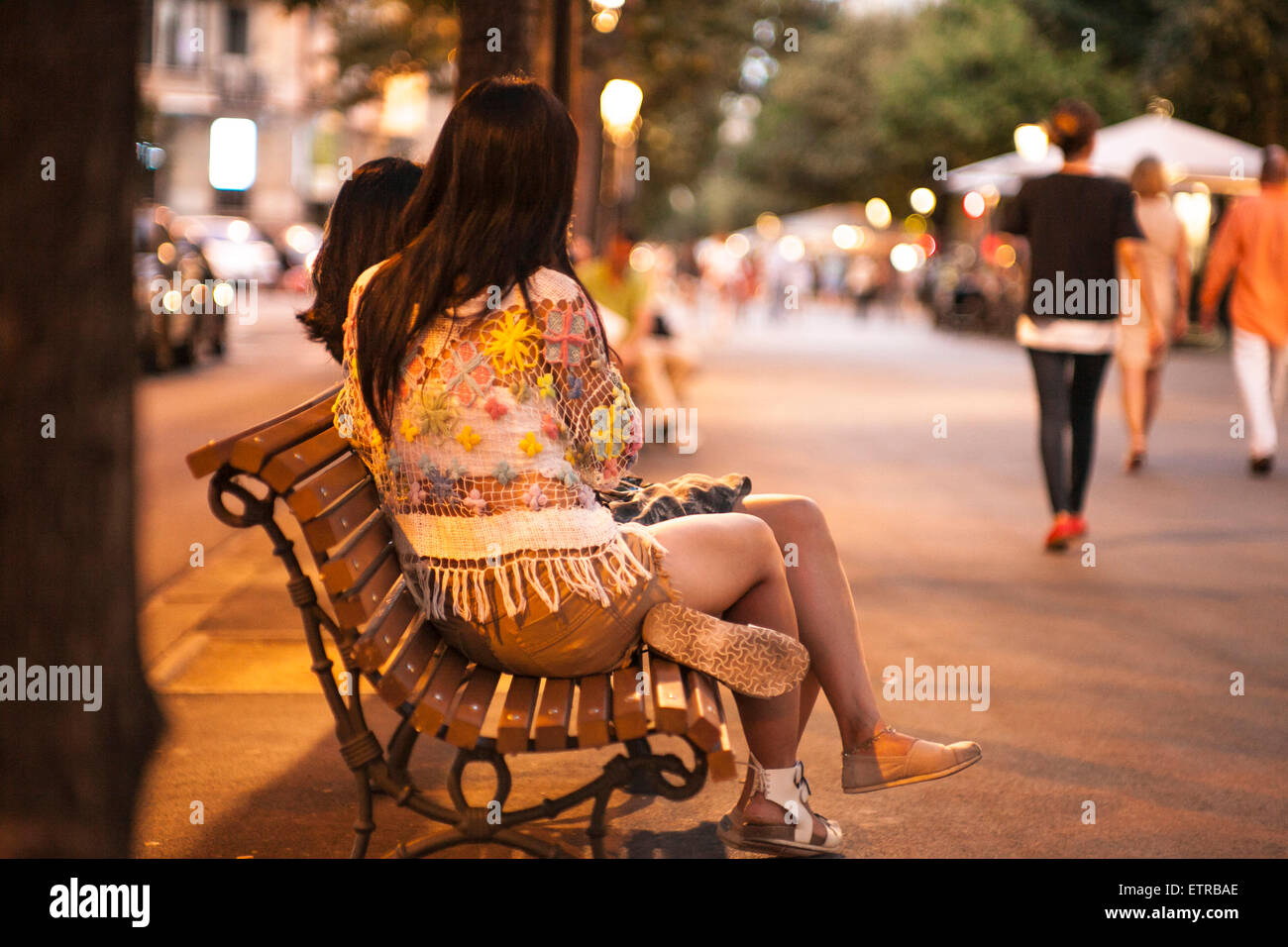 Due turisti femmina seduto su una banca di notte, Barcellona, centro visite turistiche plaza Catalunya, la piazza centrale, Spagna, Europa Foto Stock