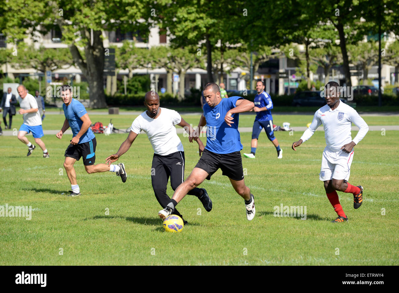 Giocatori dilettanti di calcio uomini di tutte le età giocano una partita improvvisata al parco pubblico di Annecy in Francia. Uomini che giocano a calcio nel parco Foto Stock