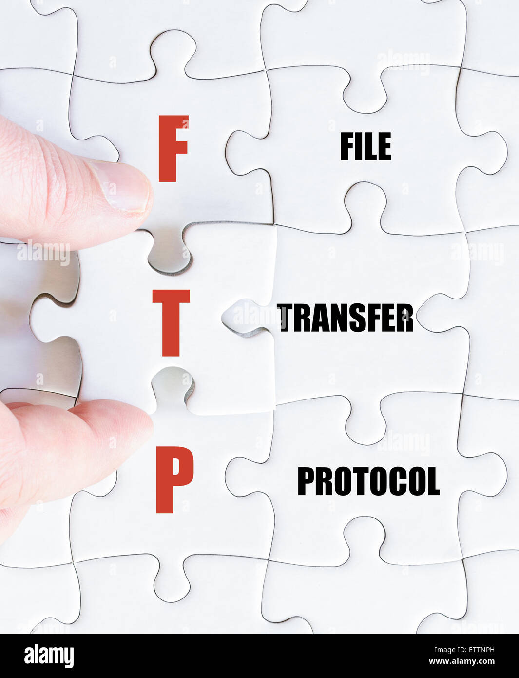La mano di un uomo di affari di completare il puzzle con l'ultimo pezzo mancante.Concetto di immagine di Business acronimo FTP come protocollo di trasferimento di file Foto Stock