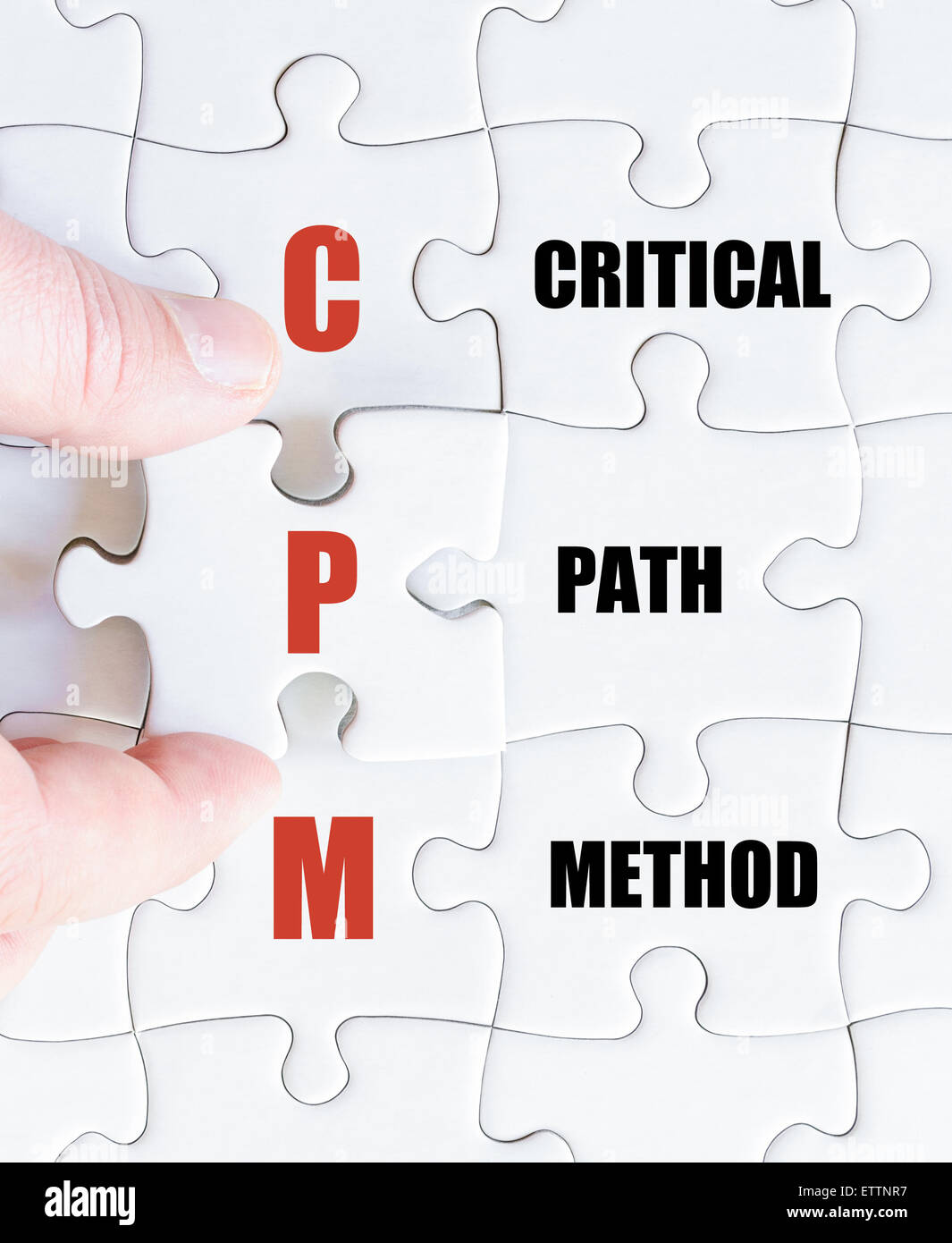 La mano di un uomo di affari di completare il puzzle con l'ultimo pezzo mancante.Concetto di immagine di Business acronimo CPM come percorso critico metodo Foto Stock