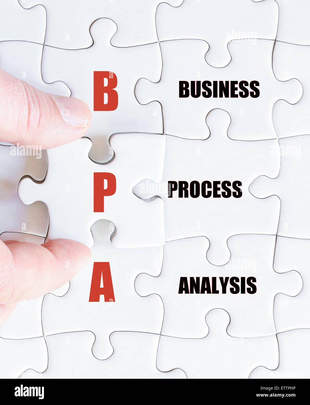 La mano di un uomo di affari di completare il puzzle con l'ultimo pezzo mancante. Acronimo di Business BPA come analisi dei processi di business Foto Stock