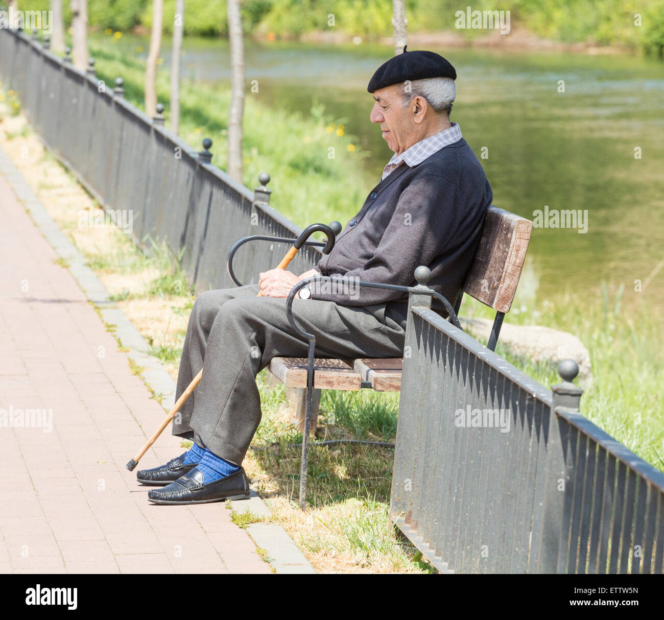Anziani uomo spagnolo tenendo la siesta sul banco vicino al fiume. Spagna Foto Stock